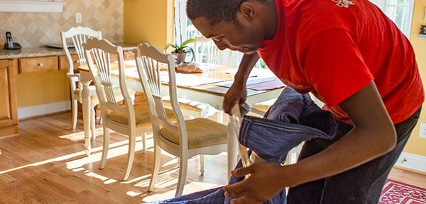 Man wrapping chair in protective blanket to prepare for residential move